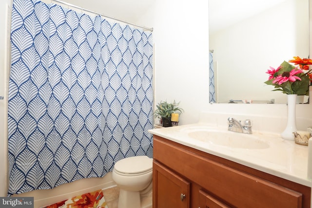 bathroom with toilet, vanity, and tile patterned flooring