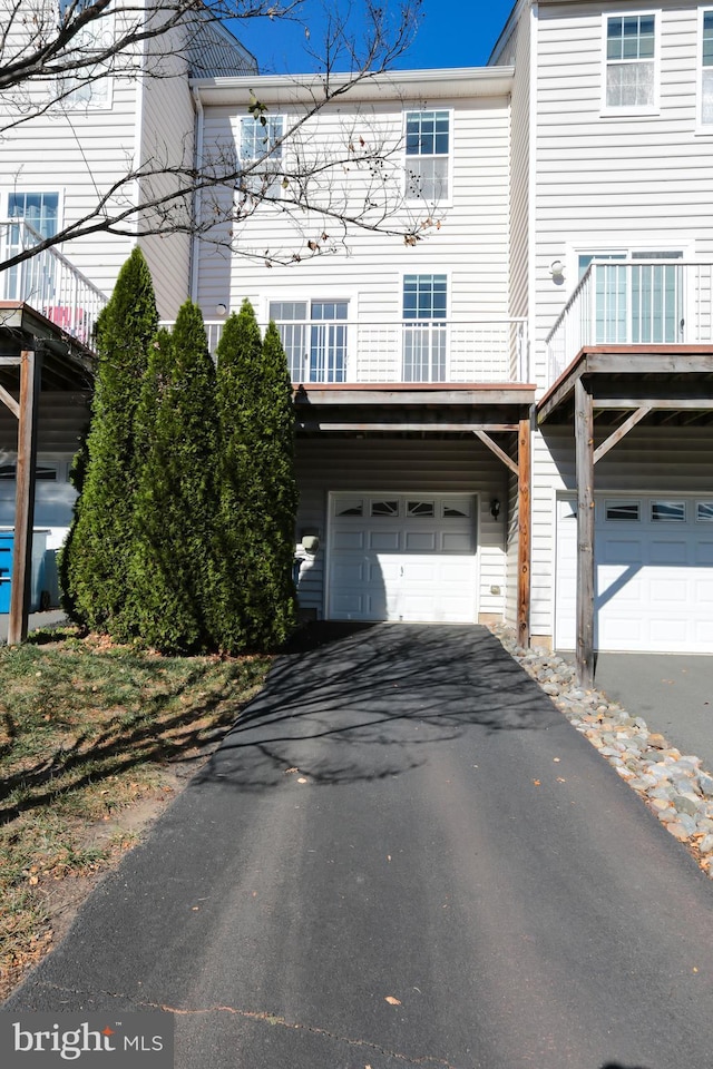 view of front of property featuring a garage and a balcony