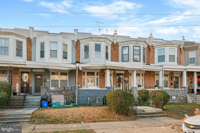 townhome / multi-family property featuring covered porch