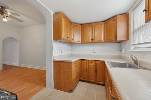 kitchen with ceiling fan, light hardwood / wood-style flooring, and sink