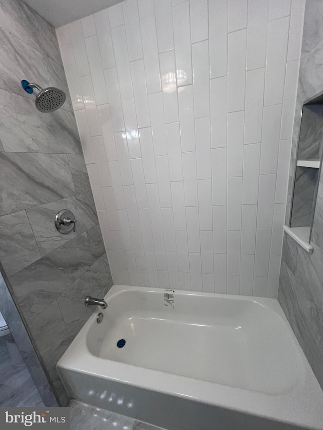 bathroom featuring tiled shower / bath