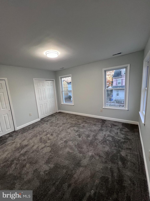 unfurnished bedroom featuring dark colored carpet