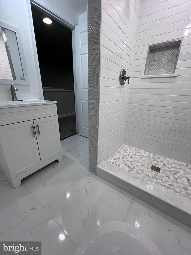 bathroom with vanity and tiled shower