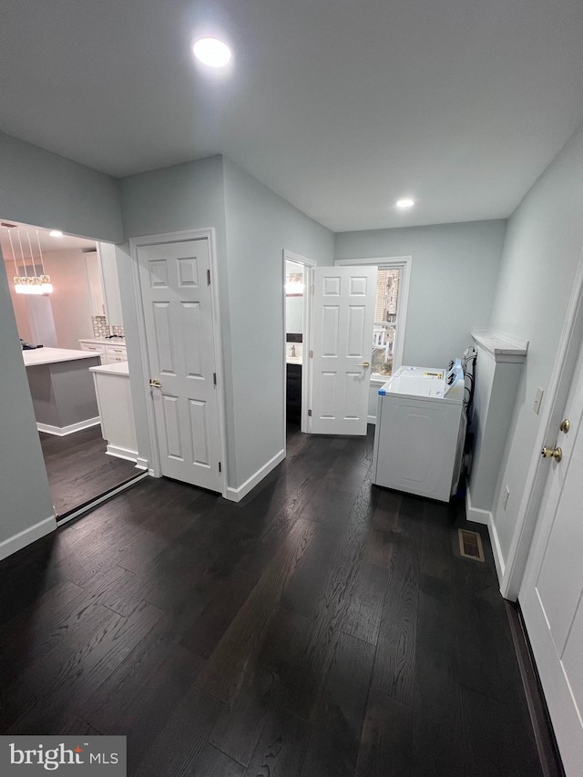 interior space with dark hardwood / wood-style flooring and washer / clothes dryer