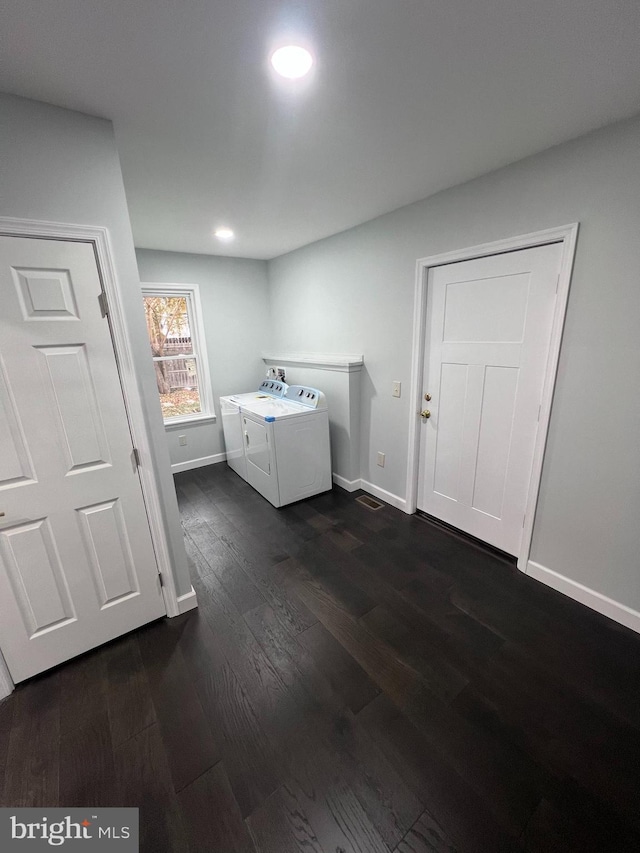 laundry room with dark hardwood / wood-style flooring and washing machine and clothes dryer