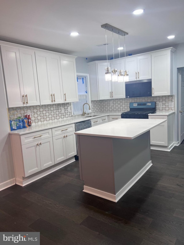 kitchen featuring black stove, backsplash, white cabinetry, and hanging light fixtures