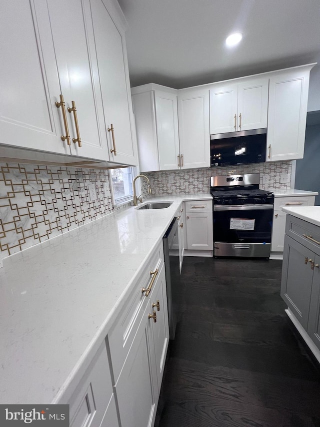 kitchen featuring dark hardwood / wood-style floors, white cabinetry, stainless steel appliances, and tasteful backsplash