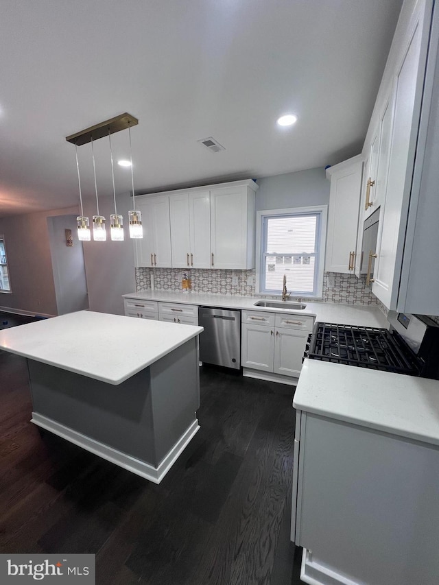 kitchen with dishwasher, sink, dark hardwood / wood-style floors, decorative light fixtures, and white cabinets