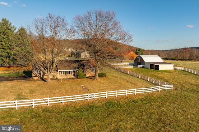 view of front of house featuring a front yard, a rural view, and an outdoor structure