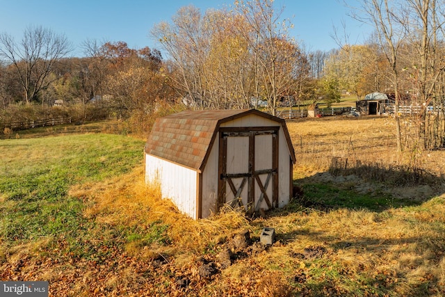 view of outdoor structure with a yard and a rural view