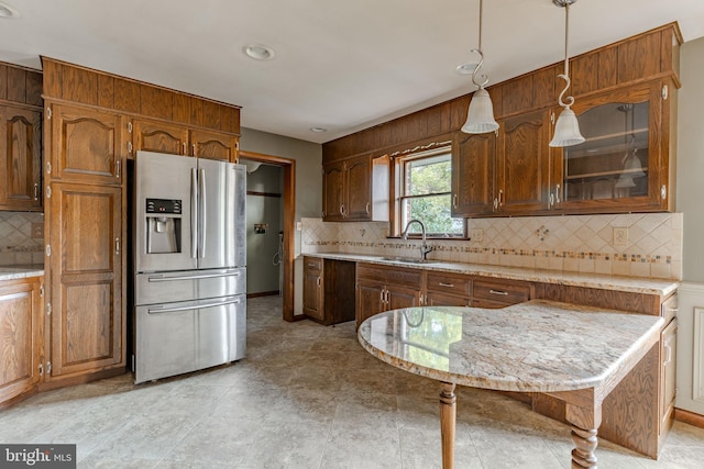 kitchen featuring stainless steel fridge, decorative light fixtures, tasteful backsplash, and sink