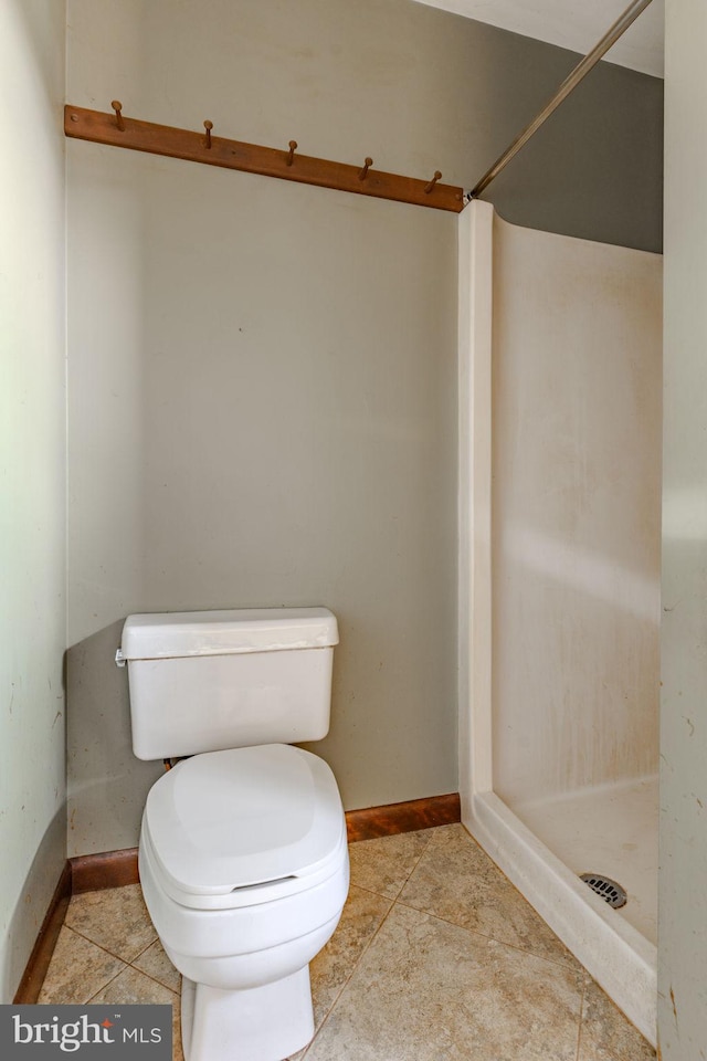 bathroom with tile patterned flooring, toilet, and walk in shower