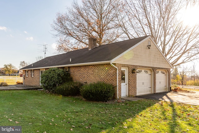 view of side of home with a garage and a lawn