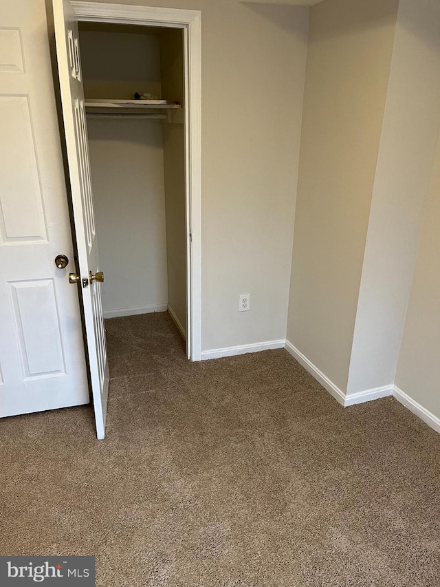 unfurnished bedroom with carpet flooring and a closet