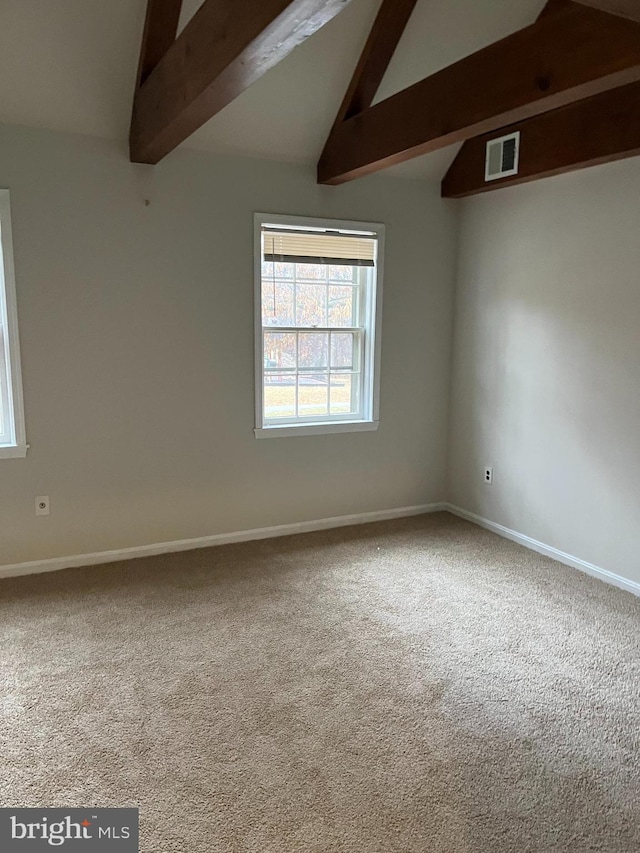 empty room with carpet flooring and lofted ceiling with beams