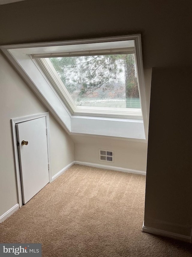 bonus room with light carpet and lofted ceiling