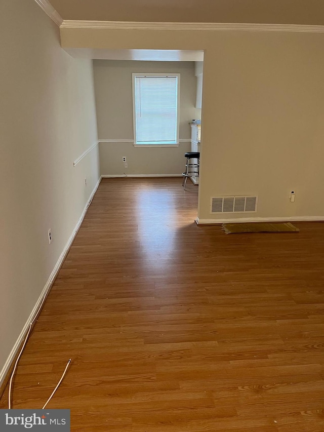 unfurnished room featuring light hardwood / wood-style floors and ornamental molding