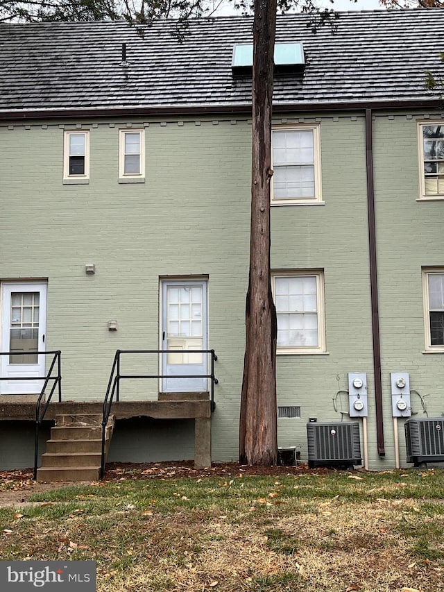 back of house featuring a yard and central air condition unit