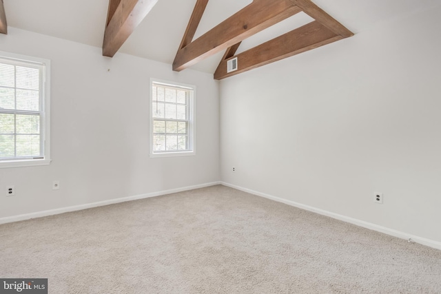 spare room featuring lofted ceiling with beams, carpet floors, and baseboards
