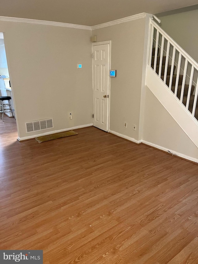 unfurnished living room with hardwood / wood-style floors and ornamental molding