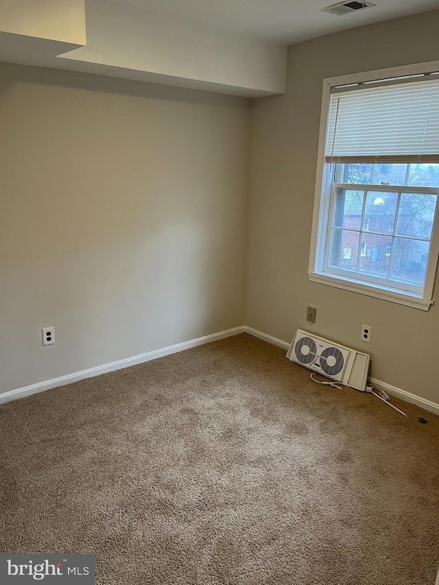 spare room featuring plenty of natural light and carpet floors