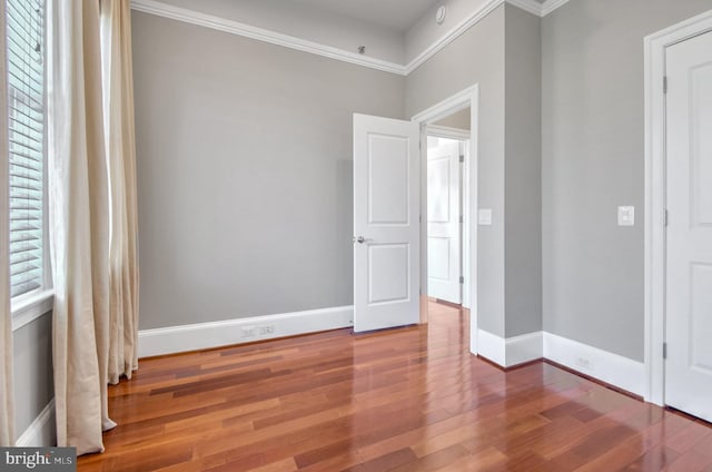 unfurnished bedroom featuring wood-type flooring and crown molding