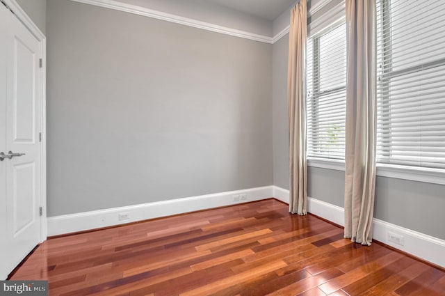 unfurnished room with hardwood / wood-style flooring, a healthy amount of sunlight, and ornamental molding