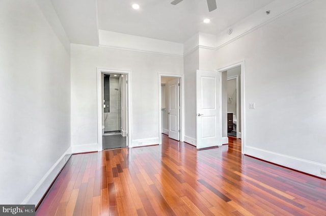 unfurnished bedroom featuring a high ceiling, ceiling fan, and dark wood-type flooring