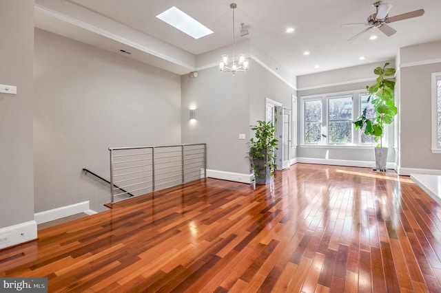 unfurnished living room with wood-type flooring and ceiling fan with notable chandelier