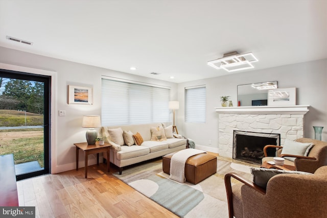 living room featuring light wood-type flooring and a fireplace