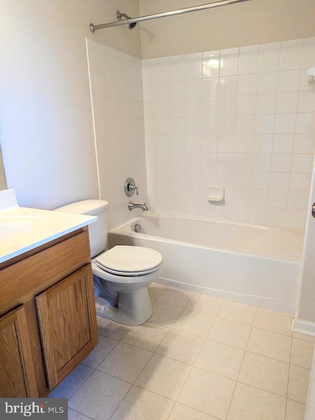 full bathroom featuring toilet, vanity, tile patterned floors, and tiled shower / bath