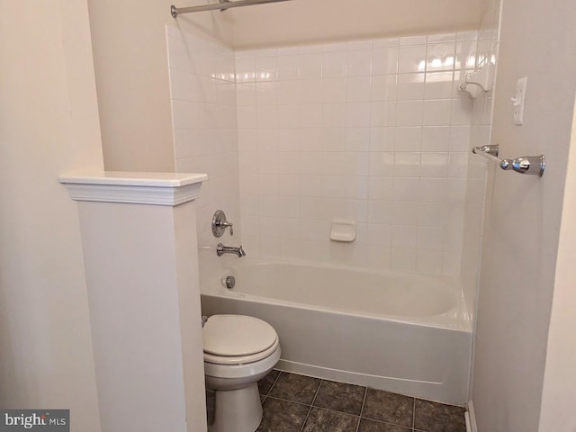 bathroom with tile patterned flooring, tiled shower / bath combo, and toilet