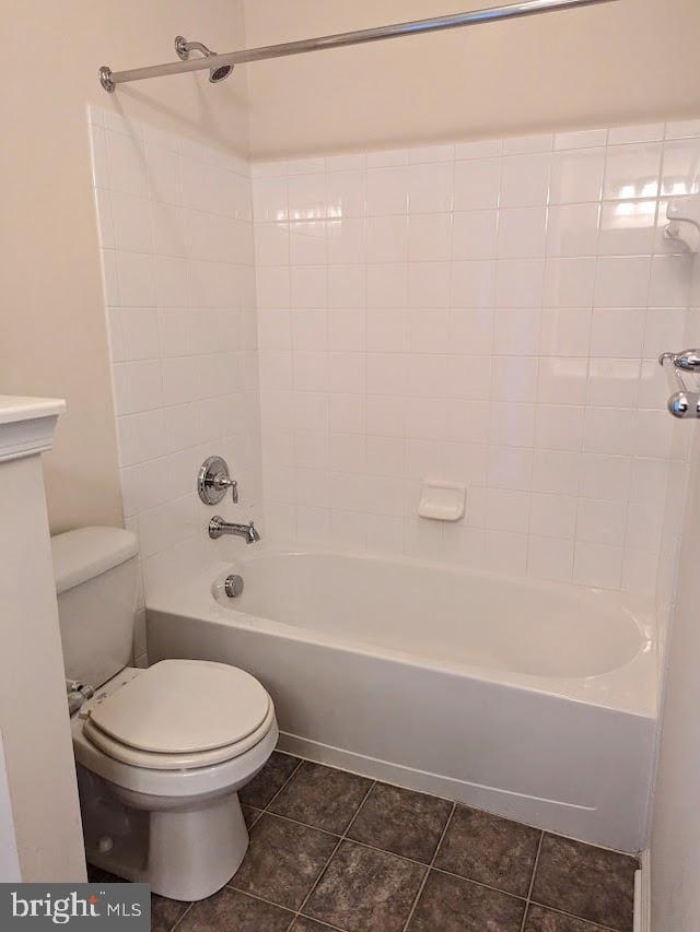 bathroom with toilet, tile patterned floors, and tiled shower / bath