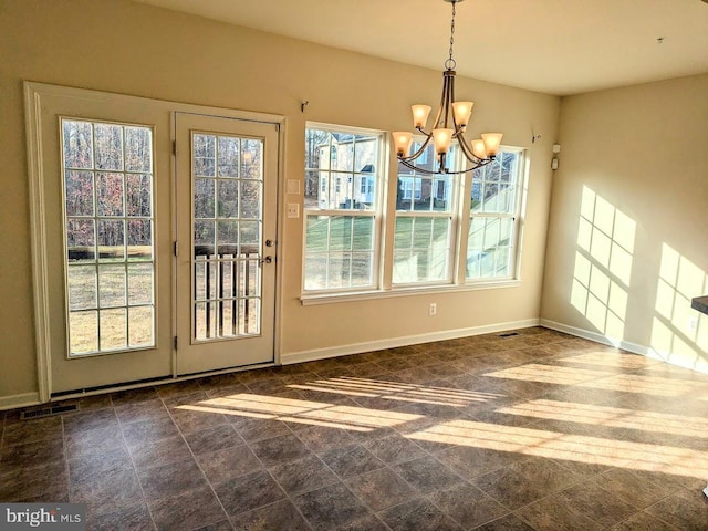 unfurnished dining area with a wealth of natural light and a notable chandelier