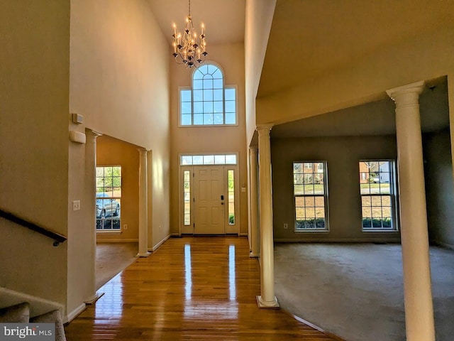 entrance foyer featuring carpet floors, a chandelier, and high vaulted ceiling