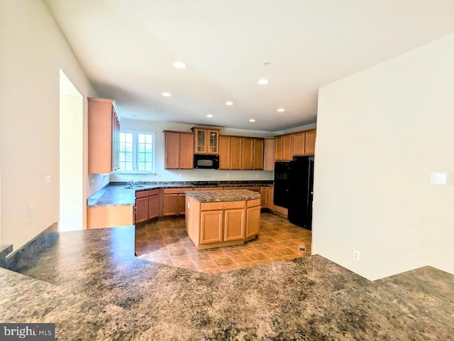 kitchen with sink, a center island, and black appliances