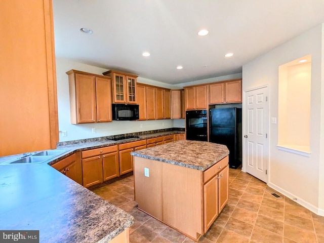 kitchen featuring black appliances, a center island, and sink