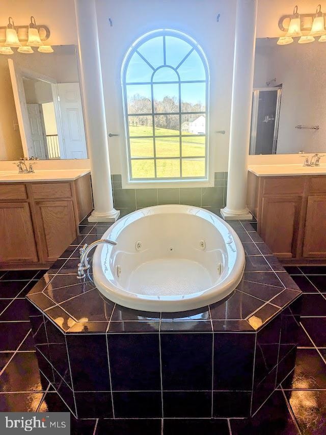 bathroom with vanity, tiled bath, and decorative columns