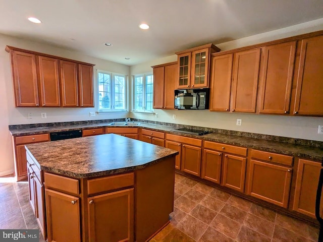 kitchen featuring black appliances, a center island, and sink