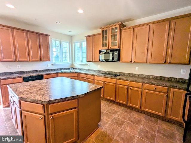 kitchen featuring black appliances, a kitchen island, and sink