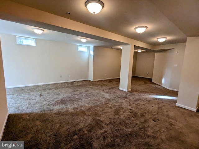 basement featuring dark colored carpet and a wealth of natural light