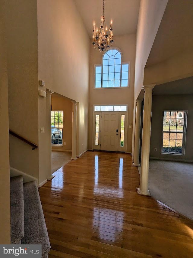 foyer with a high ceiling, a healthy amount of sunlight, and a notable chandelier