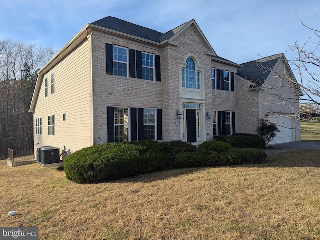 colonial inspired home featuring central air condition unit, a front lawn, and a garage