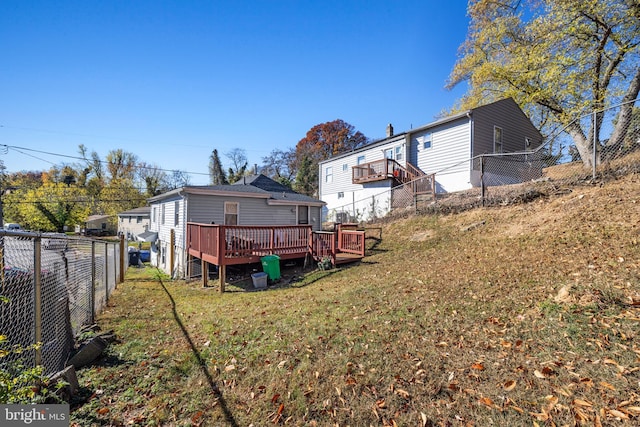 rear view of house with a lawn and a deck