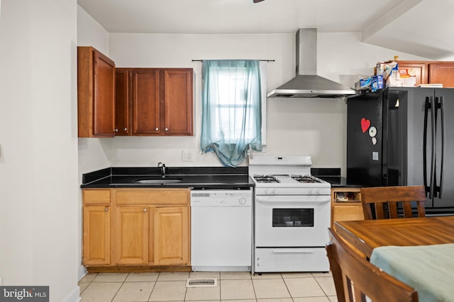 kitchen with white appliances, sink, light tile patterned floors, and wall chimney range hood