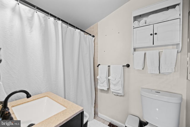 bathroom featuring vanity, curtained shower, and toilet