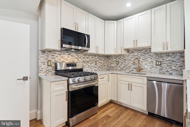 kitchen with white cabinetry, sink, light hardwood / wood-style flooring, and appliances with stainless steel finishes