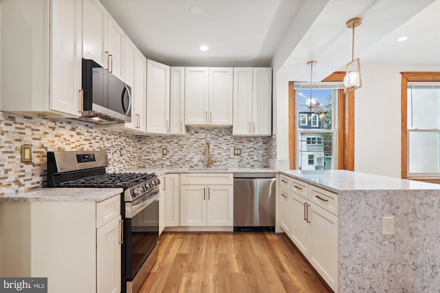 kitchen featuring white cabinets, light wood-type flooring, and stainless steel appliances