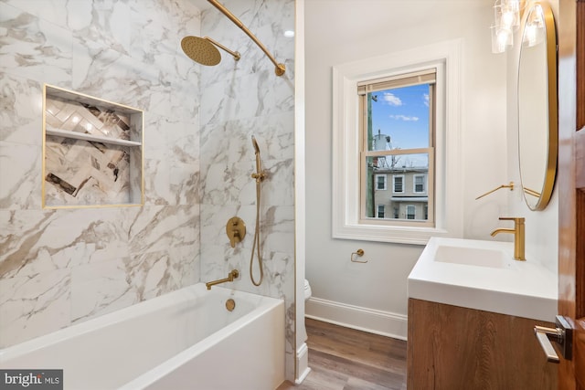 full bathroom featuring hardwood / wood-style flooring, vanity, toilet, and tiled shower / bath