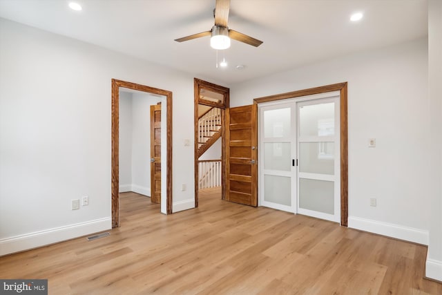 empty room with ceiling fan and light hardwood / wood-style floors